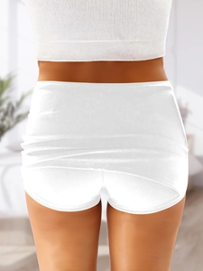 Rear view of white low-waisted mini skirt with built-in shorts in stretch fabric