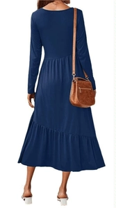 Détail d'une robe longue bleu marine à manches longues avec taille plissée et volants