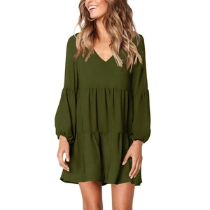 Detail view of the V-neck and tiered ruffle skirt of this olive green long sleeve dress