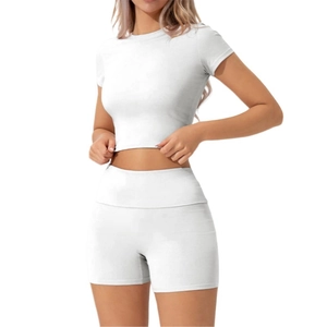 Vista frontale del set crop top bianco a maniche corte e pantaloncini sportivi a vita alta