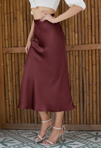 Detail of elegant wine red satin midi skirt with side slit and silky drape texture
