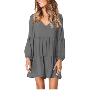 Detail of dark grey V-neck dress featuring layered ruffle skirt and puff lantern sleeves