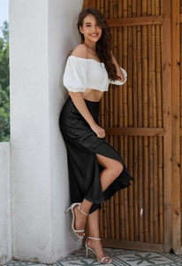 Elegant satin midi skirt detail showing the high side slit and smooth fabric texture