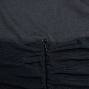 Détail d'une fermeture éclair invisible et tissu plissé sur une robe midi noire ajustée