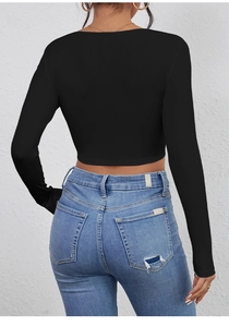 Rear view of black ribbed long sleeve crop top paired with distressed blue jeans