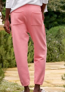 Dettaglio posteriore dei pantaloni jogger rosa con tasche a taglio vivo e polsini