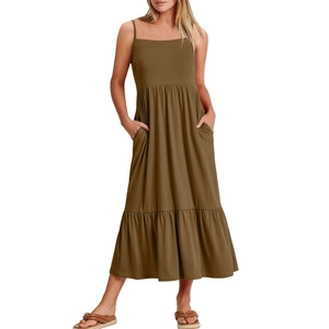 Detail of a tiered sleeveless dress in tan with spaghetti straps and side pockets