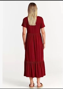 Detail of tiered skirt and pleated hemline on a burgundy short-sleeved casual dress