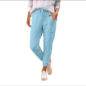 Dettaglio di pantaloni jogger azzurri con vita elastica a coulisse e ampie tasche laterali