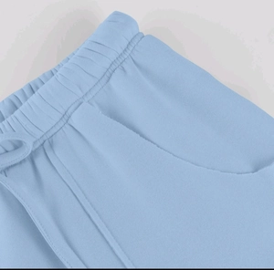 Dettaglio della vita elastica con coulisse e tasche con bordo a taglio vivo sui pantaloni casual