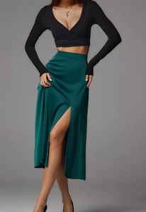 Detail view of smooth dark green satin skirt featuring a high waist and side split design