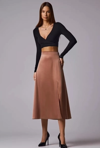 Macro shot of copper satin midi skirt featuring a side slit and smooth silky texture