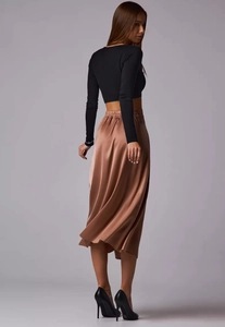 Detail of champagne gold satin midi skirt with elegant high waist and silky draping fabric