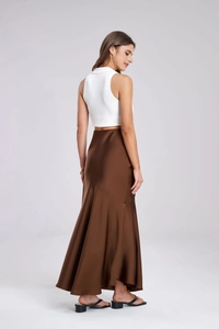 Full view of women's sleeveless white knit top and dark brown satin mermaid skirt