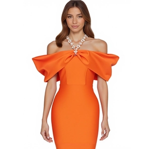 Detail of rhinestone halter neck strap and large bow on vibrant orange off-shoulder dress