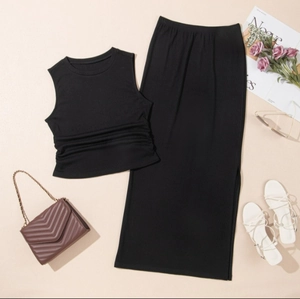 Flat lay of black sleeveless crop top with ruched side and matching side slit maxi skirt