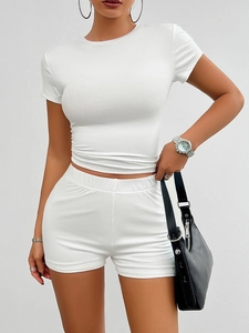 Detailed close-up of white slim-fit knit set with ribbed crewneck and ruched hem top