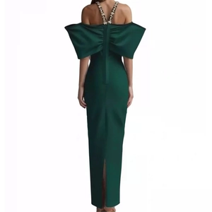 Detail of dark green evening gown featuring a large back bow and rhinestone straps