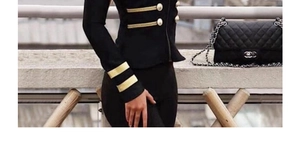 Close-up of military style blazer with gold buttons and decorative sleeve stripes