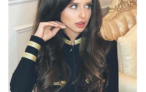 Detail of gold braided trim and metallic buttons on black military style jacket sleeve