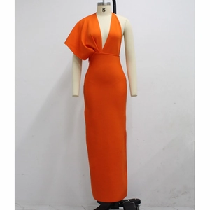 Detail view of the deep V-neckline and asymmetrical single shoulder drape on orange gown