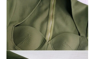 Détail de la robe vert olive avec découpe sur la poitrine et fermeture éclair