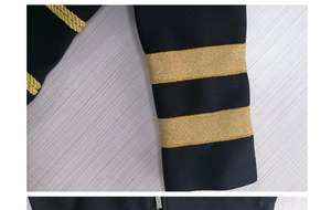 Detailed view of black knit sleeve cuffs featuring decorative gold metallic stripes