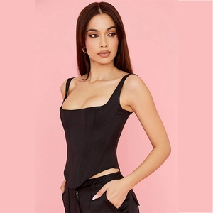Women's black corset top with fishbone structure and curved hem on pink background
