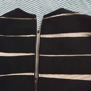 Detail eines silbernen Metallreißverschlusses an schwarz-weiß gestreiftem Kleid