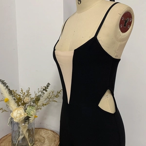 Women's black bodycon jumpsuit with beige V-patch, side cutouts and thin spaghetti straps