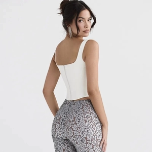 Close-up of a white corset-style tank top featuring a discreet vertical back zipper detail