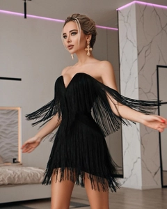 Détail de la mini robe noire à franges avec décolleté en V profond et longs pompons