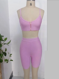 Pink two-piece summer sports set with gold zip-up V-neck top and ribbed cycling shorts