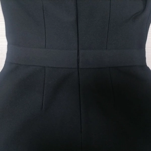 Detail view of back invisible zipper and waist stitching on black bandage dress