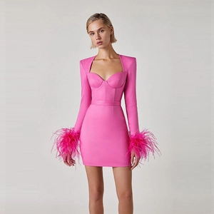 Detail of hot pink mini dress featuring fluffy ostrich feather cuffs and corset style bodice