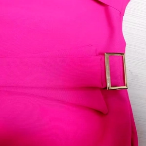 Détail du tissu côtelé rose fuchsia avec une boucle métallique rectangulaire élégante