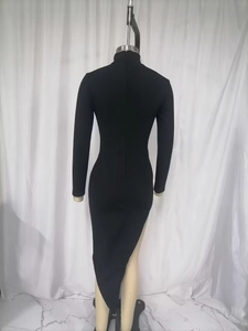 Detail of black ribbed knit dress featuring turtleneck and asymmetrical hemline cut