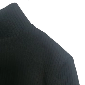 Detailed view of black rib-knit fabric texture and high neckline stitching quality