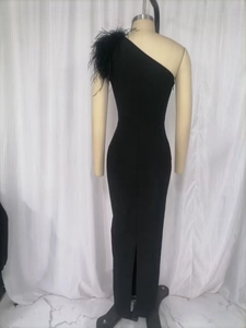 Detail of elegant black one-shoulder dress featuring dense ostrich feathers and sleek slit