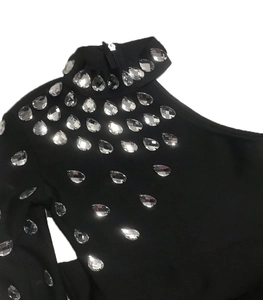 Macro detail of teardrop rhinestones on black elastic shoulder of a bandage dress