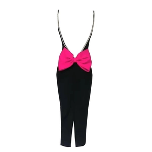 Détail du dos d'une robe noire ajustée avec un grand nœud fuchsia et bretelles en diamants