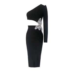 Détail de la découpe à la taille avec applique papillon argentée sur robe noire