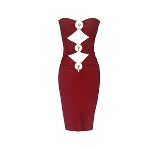 Détail de la robe moulante rouge foncé avec découpes évidées et boucles métalliques dorées