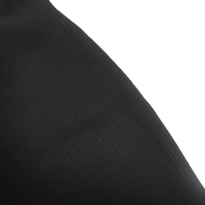 Vue détaillée de la texture en maille côtelée noire de cette robe mini élégante