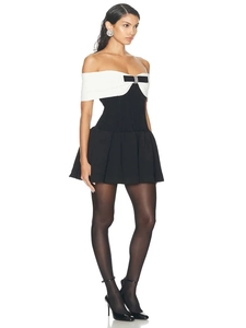 Mini robe élégante contrastée noire et blanche avec détail de nœud et col bardot