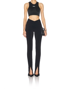 Detail of slim-fit high-waisted black trousers featuring a stylish front slit hem design