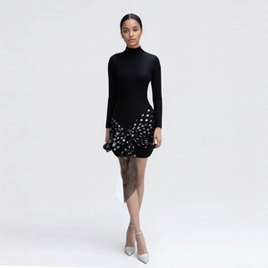 Close-up of elegant black dress featuring oversized polka dot bow and sheer mesh detail