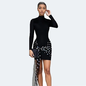 Detail of black mini dress featuring a sheer tulle overlay with silver sequin polka dots