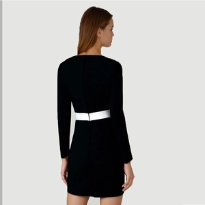 Dettaglio del retro di un abito slim fit con cintura bianca a contrasto e tessuto nero