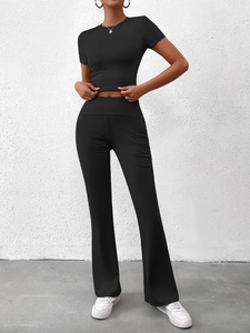 Détail d'un ensemble noir deux pièces avec haut court ajusté et pantalon évasé
